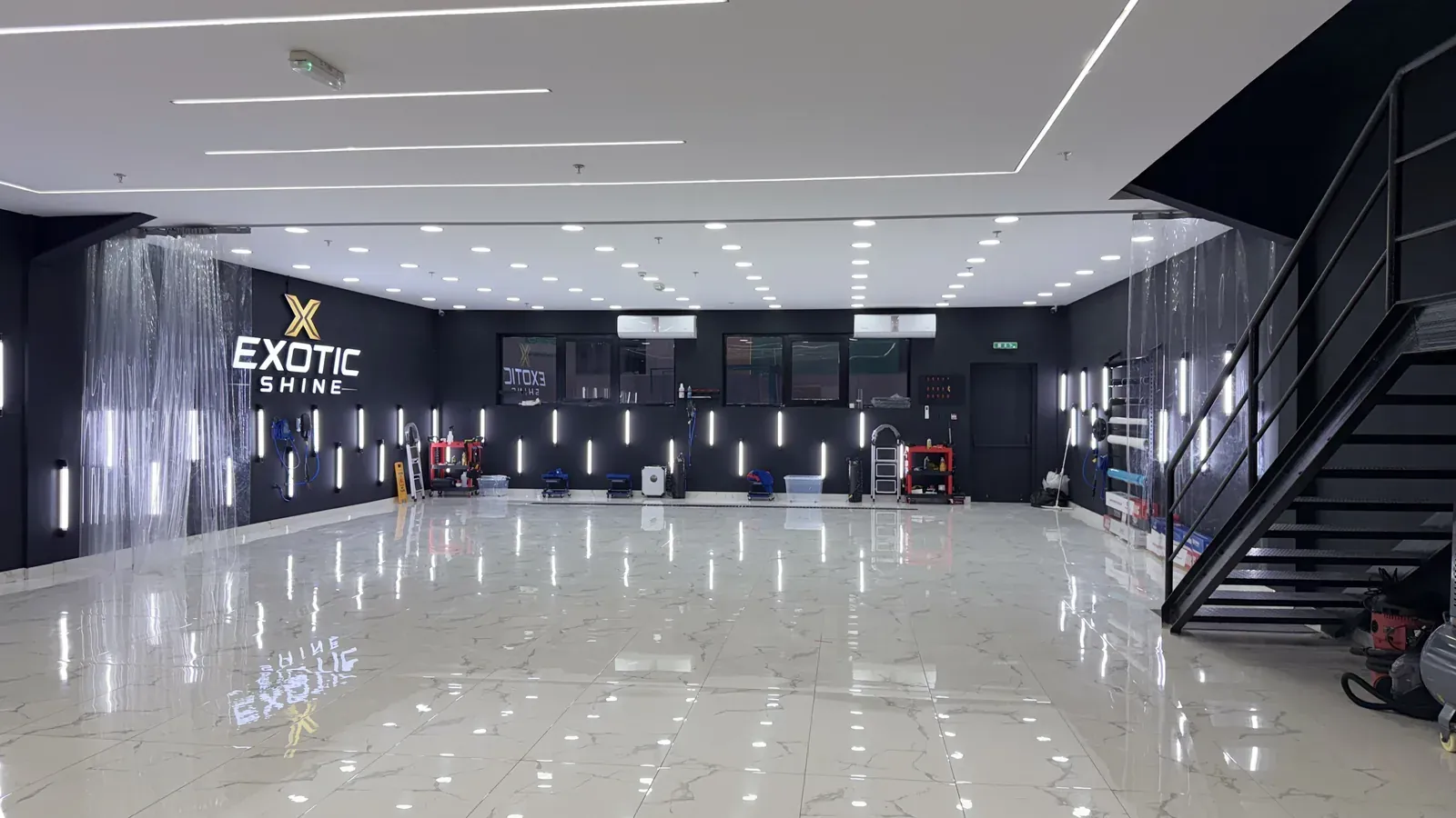 The full workshop floor with the Exotic Shine wall and the stair to the mezzanine